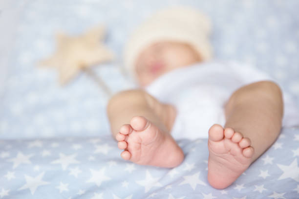 Cute little baby is resting peacefully and adorably with a star wand on a soft, star patterned blanket