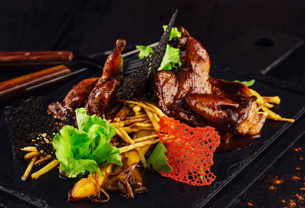 istock Grilled quails served on stone plate with potatoes and mushrooms 2176061766