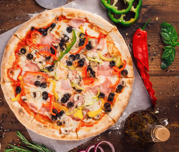 istock Delicious pizza lying on wooden table surrounded by fresh ingredients 2176061802