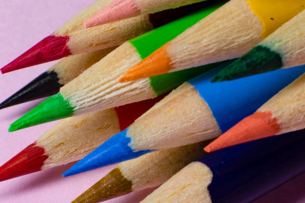 Colored pencil with dark background with upward peaks, colorful, artistic background, school and studies.