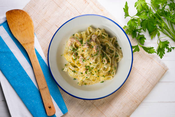 istock Fresh Italian pasta with salmon and cream. Top view table with decorations. 2176066907