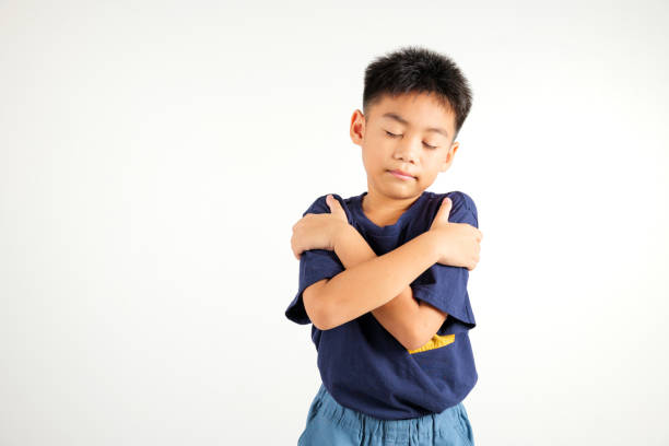 istock Happy young child smiling Asian boy hugging herself remember a moment studio short isolated on white background, Self care and self esteem concept 2176069653