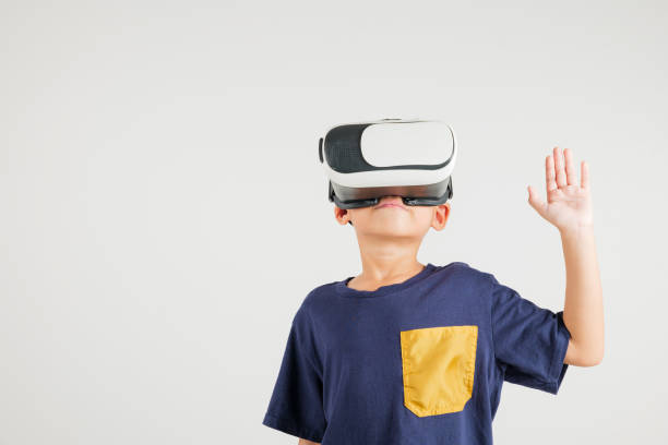 istock Portrait Asian smiling kid boy touching at something in a virtual reality glasses headset studio shot isolated white background, Excited happy primary child using VR play simulation 2176069746