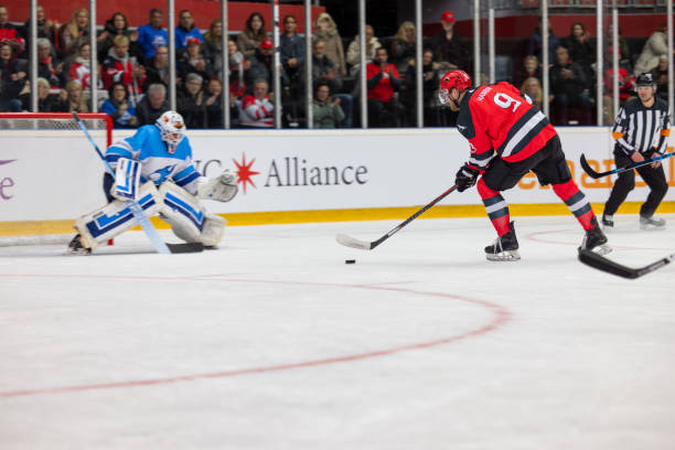 istock Hockey Player Shooting Toward the Goalie 2176074732