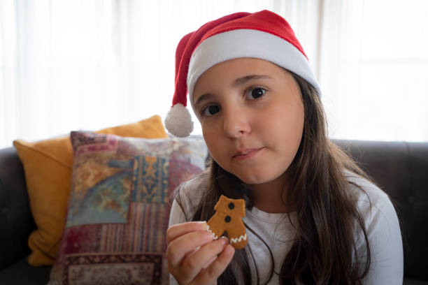 Portrait smiling girl eating gingerbread cookie
