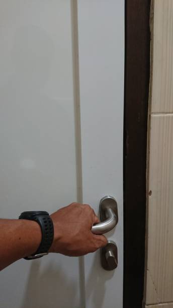 istock Man's Hand using black watch, Opening a White Door with a Silver Handle 2176078296