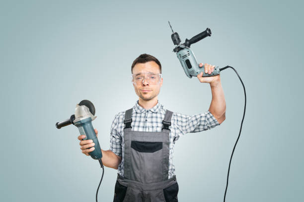istock Portrait of a Handyman Holding Power Tools in Both Hands 2176079286