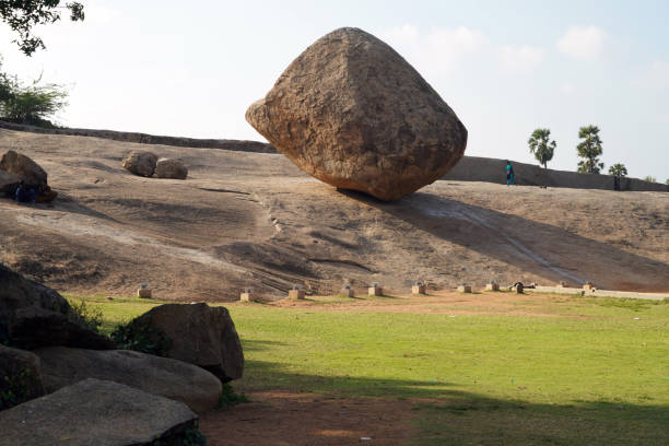 Two large granite boulders dominate the foreground, surrounded by dense green shrubs. A clear blue sky with wispy clouds stretches above, creating a rugged yet tranquil Western Cape nature scene. Ideal for nature, travel, outdoor, landscape, and adventure-themed stock imagery and projects.