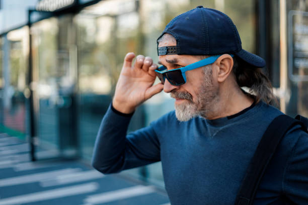 istock Man adjusting sunglasses while walking in city 2176087232