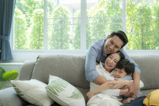 smiling family sitting on sofa - con trai tôi hình ảnh sẵn có, bức ảnh & hình ảnh trả phí bản quyền một lần