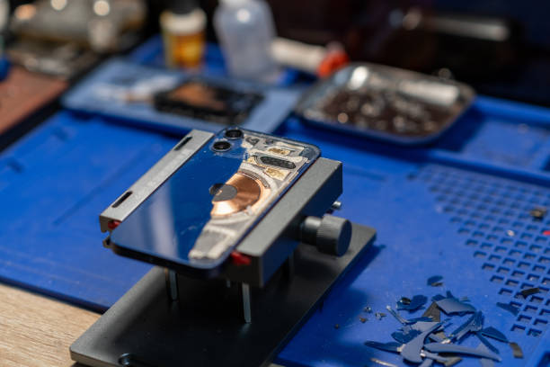 istock Repairing Smartphone Back Glass, The image shows a technician working on a phone 2176091478