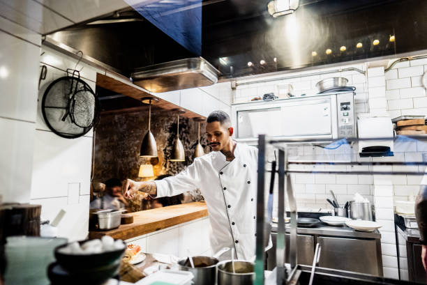 istock Young chef preparing food on a plate at restaurant kitchen 2176094051