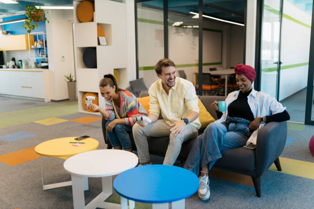 istock Coworkers playing video games and drinking coffee during a break in a startup office 2176094312