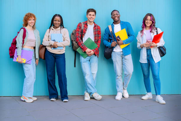 istock Group of smiling diverse students on university campus holding notebooks 2176094397