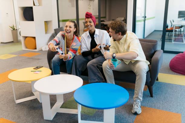 istock Colleagues enjoying playing video game during work break at creative startup 2176094489