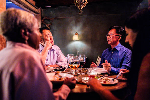 istock Coworkers talking and eating during dinner at restaurant 2176094535
