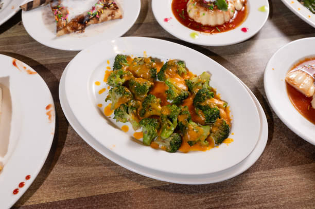 istock Steamed Broccoli Drizzled with Cheddar Cheese Sauce 2176094659
