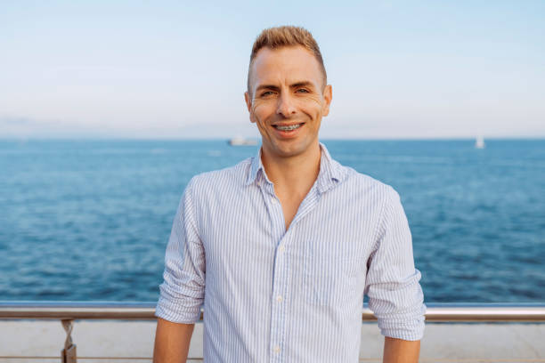 istock Young man with brackets stands near sea 2176094722