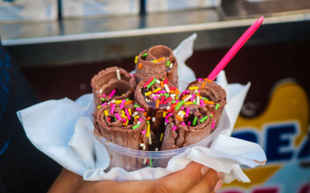 istock Chocolate Stir-fried ice cream Roll with meses topping in a cup made by hand. Hand holding a bowl of rolled ice cream 2176095417