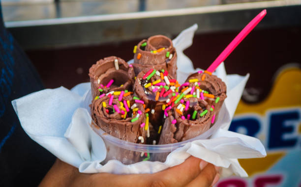 istock Chocolate Stir-fried ice cream Roll with meses topping in a cup made by hand. Hand holding a bowl of rolled ice cream 2176095449