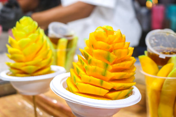 istock Display of mango slices in flower shape. or rujak, mango with spicy peanut sauce. Mango skewer in flower shape 2176096721