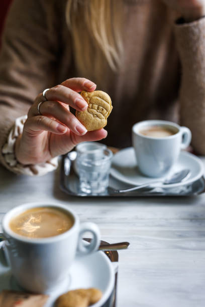 istock Woman drinks coffee in cafe and holding small cookie 2176099022