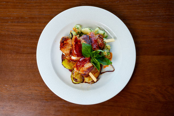 Meat chops grilled on skewer and served with gnocchi and zucchini in fine dining