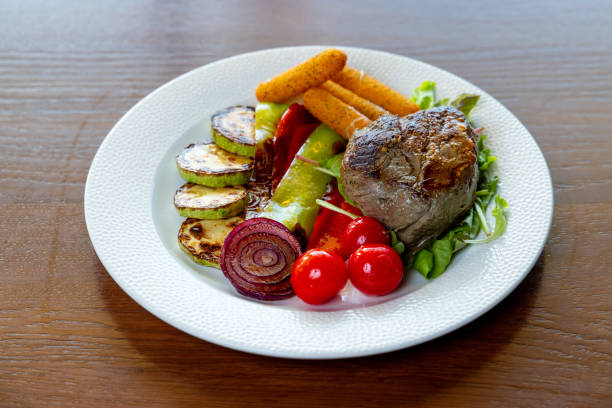 Roast meat with baked potato, grilled zucchini and paprika in fine dining