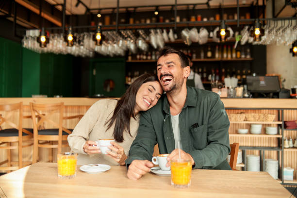 istock Couple enjoying at a cozy cafe with warm drinks and laughter in a vibrant, modern setting on a sunny afternoon 2176101460