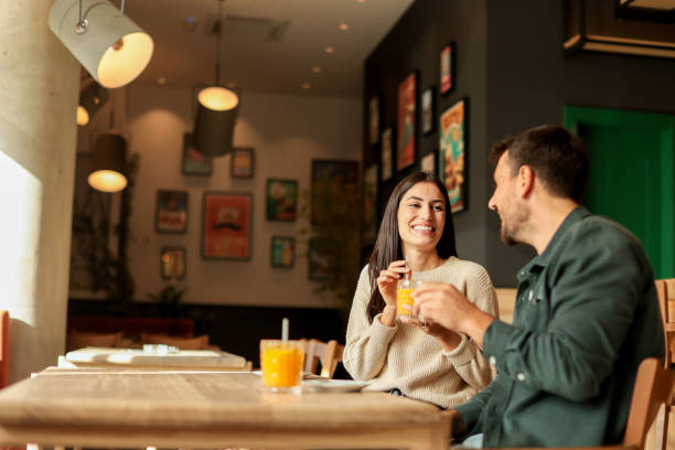 istock Couple enjoying at a cozy cafe with warm drinks and laughter in a vibrant, modern setting on a sunny afternoon 2176101463
