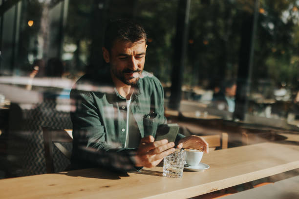 istock Toughtful man savoring coffee alone at a cozy cafe on a sunny day while lost in contemplation by the window 2176101632