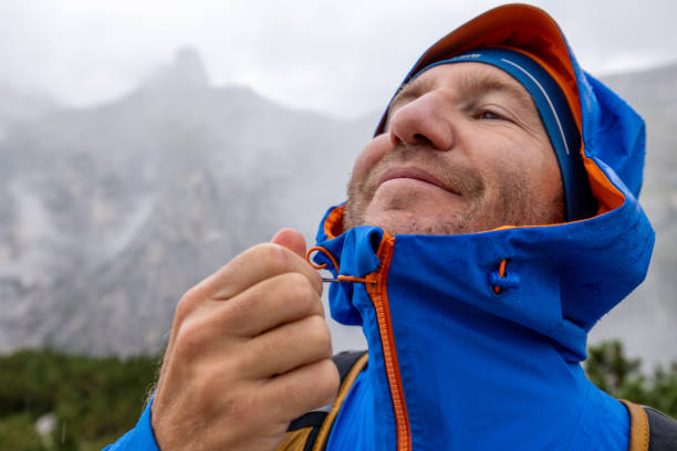 istock Hiker Zipping Up Rain Jacket in the Mountains 2176102433