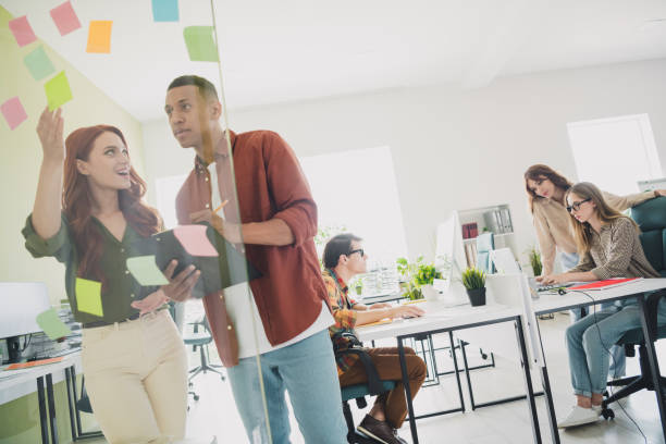 istock Photo of successful boss lady talking to employee guy explaining some details about future company strategy indoors office 2176103162