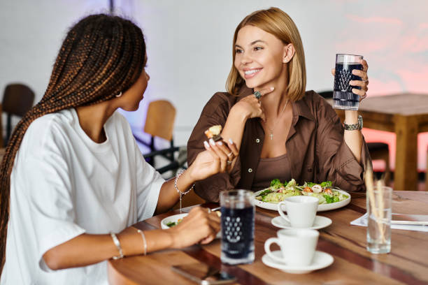 istock Two women share laughter and drinks in a cozy cafe while enjoying a delicious meal together 2176106873