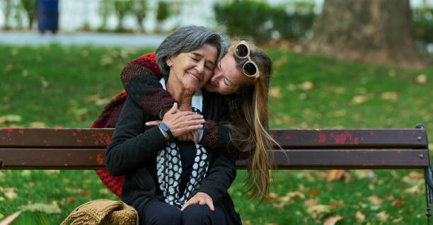 Embracing Generations: A Daughter's Love and Support for Her Senior Mother on a Sunny Day in the Park