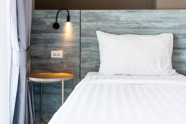 istock White pillow and bed sheet at hotel bedroom. 2176107707
