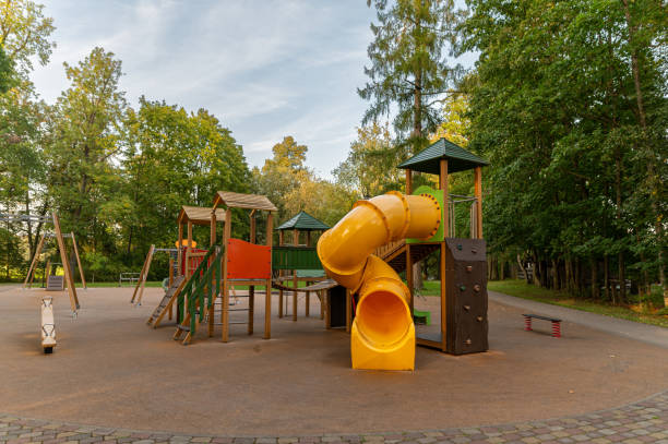 istock Childrens playground with slide and climbing structures in a green park during the day 2176107737