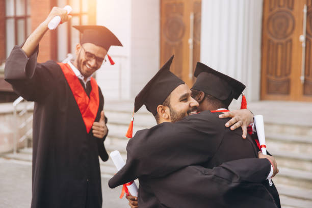 istock Joyful Graduation Day Celebration with Happy Graduates Embracing and Cheering Outside University Building 2176110484
