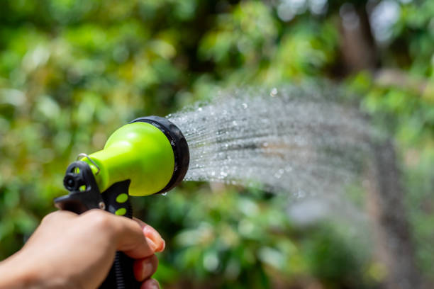 istock Hand holding a watering hose spray in the garden close up image. 2176111749