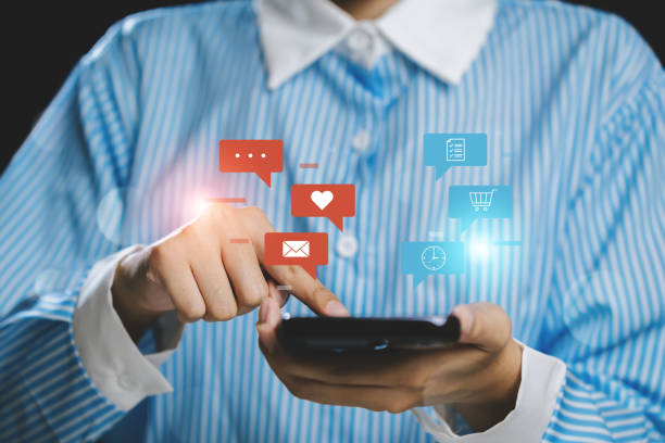 istock Person using smartphone with social media icons floating above, showcasing digital communication. 2176114487