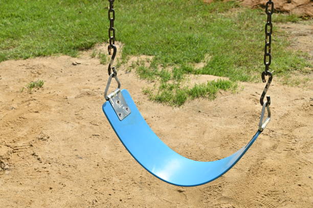 Focus on blue swing at summer playground.