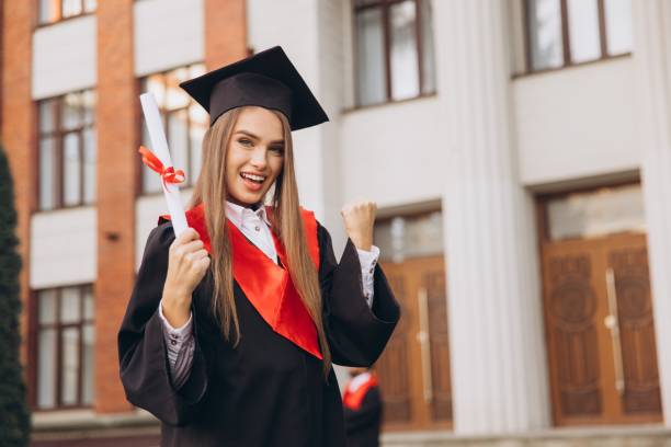 istock Cheerful Graduate Celebrating with Diploma in Hand Outside University Building 2176117103