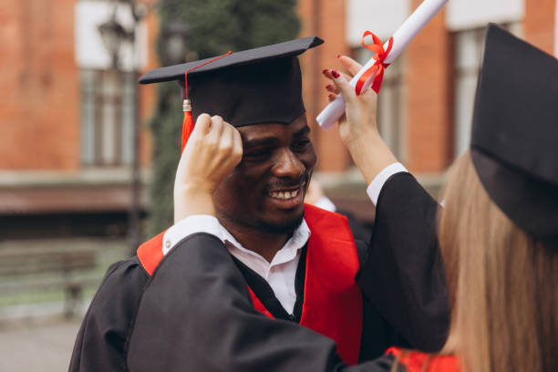 istock Smiling Graduate Receives Congratulations During Graduation Ceremony With Diploma 2176118443