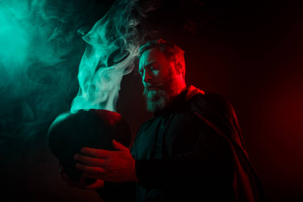 Photo of wizard warlock hold cauldron making poison magic ritual halloween night isolated on dark mysterious background.