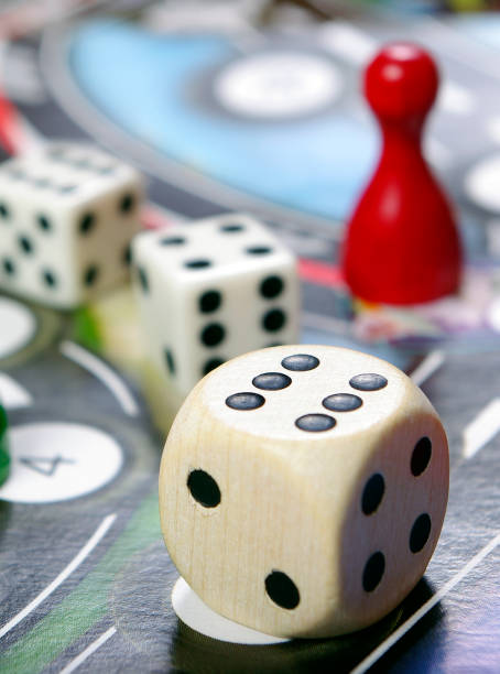 istock colorful play figures with dice on board 2176124057