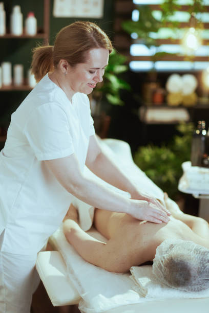 istock massage therapist in massage cabinet massaging clients back 2176124530