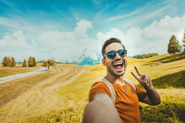 istock Happy man taking selfie with smart mobile phone over mountains background - Cheerful hiker having fun climbing outside - Hiking, travel and technology life style concept 2176126314