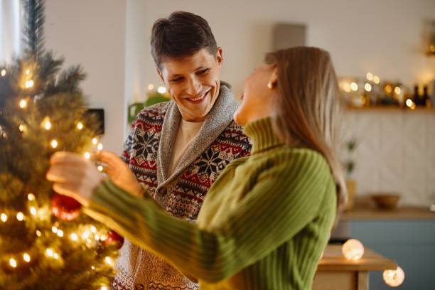 istock Lovely couple decorating Christmas tree 2176127882