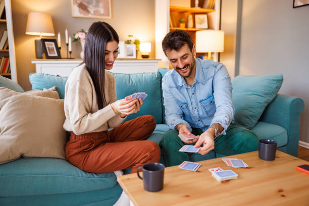 istock Couple having fun playing card games at home 2176129410
