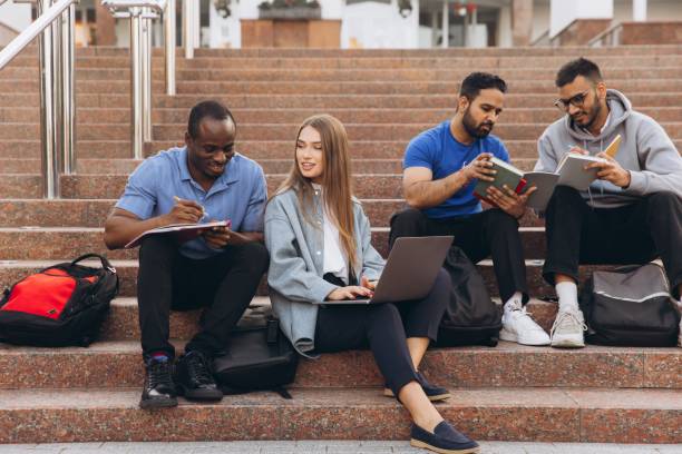 istock Diverse Group of Students Studying Together Outdoors on University Campus Steps with Laptops and Notebooks 2176130434